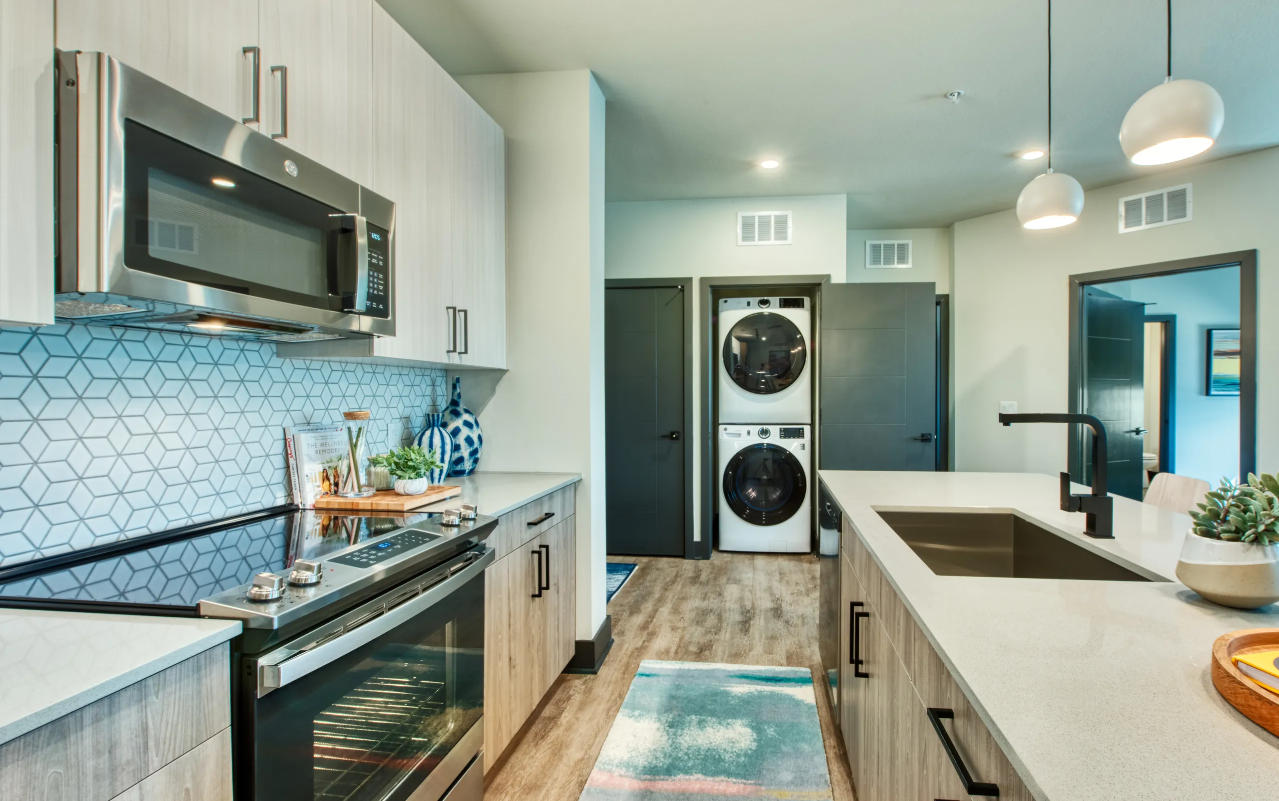 A kitchen with a stacked washer and dryer in a Canvas Tempe apartment