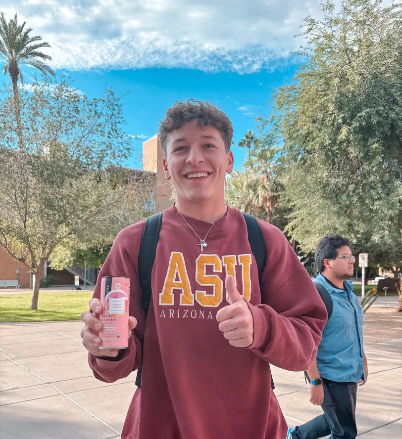 A student in an ASU sweatshirt walking across the Tempe campus